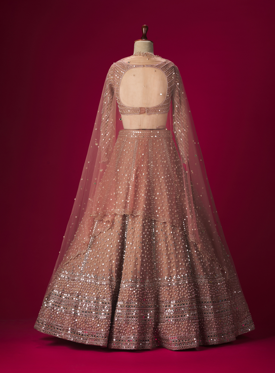 Back view of the mauve mirror and pearl work lehenga set on a mannequin