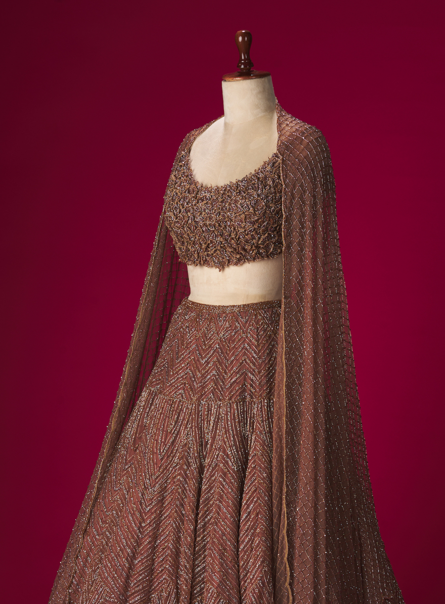 Brown lehenga with 3D flower embellished blouse and beaded dupatta, side view on a mannequin