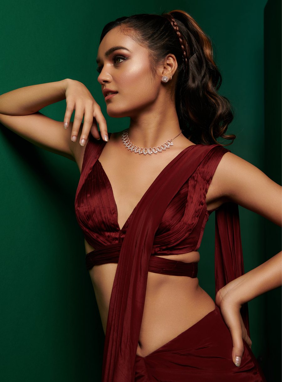 Close-up of the dark maroon pleated cross body blouse with drape