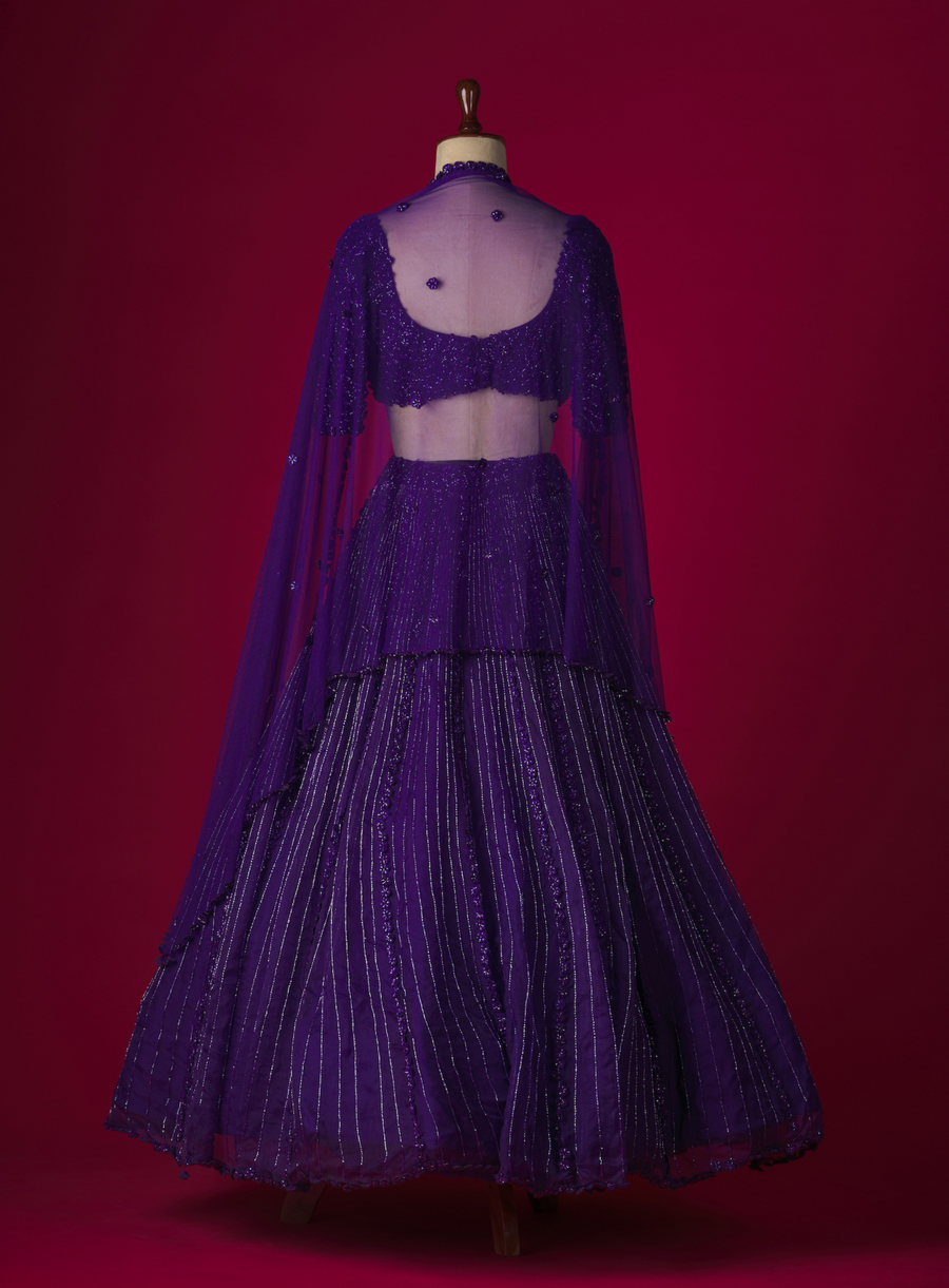 Back view of the purple lehenga with embellished blouse and sheer dupatta on a mannequin