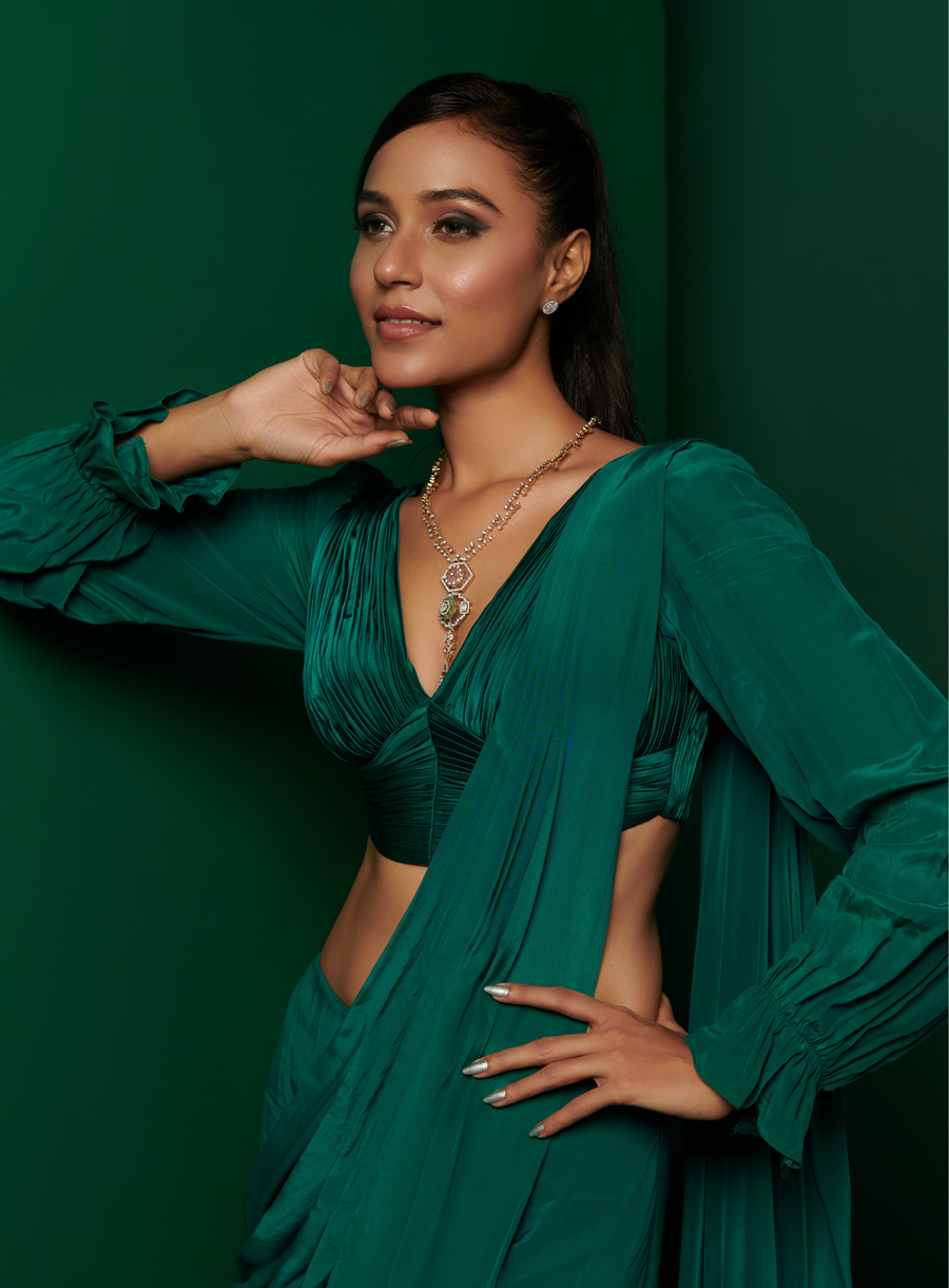 Bottle green pleated V-neck blouse with ruffled full sleeves and skirt drape saree