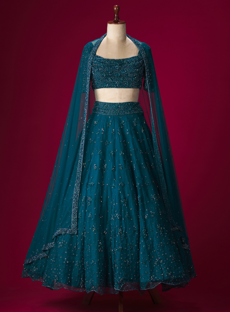 Imperial blue organza lehenga with hand-embellished cowl neck blouse in cutdana and crystal work