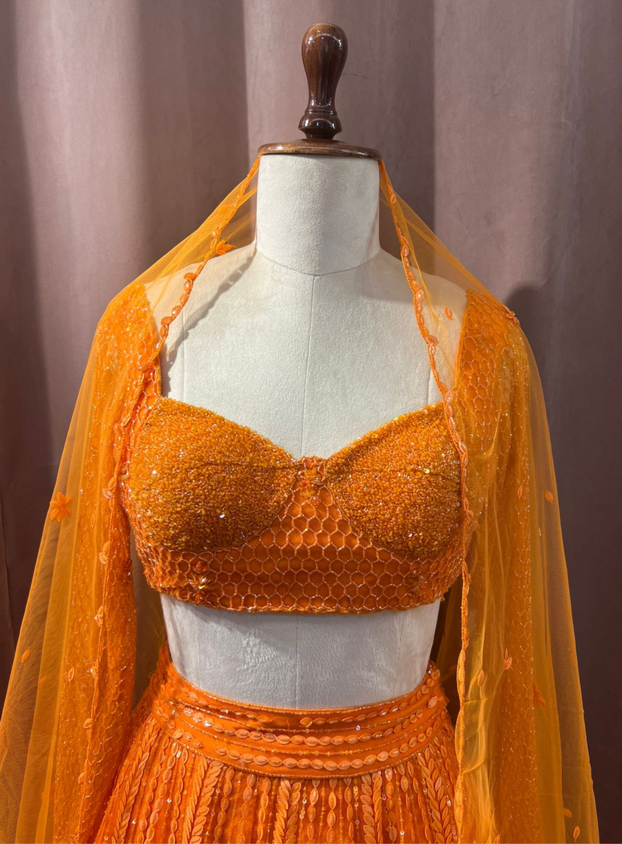 Close-up of the orange sequin-embellished blouse with honeycomb detail and sheer dupatta