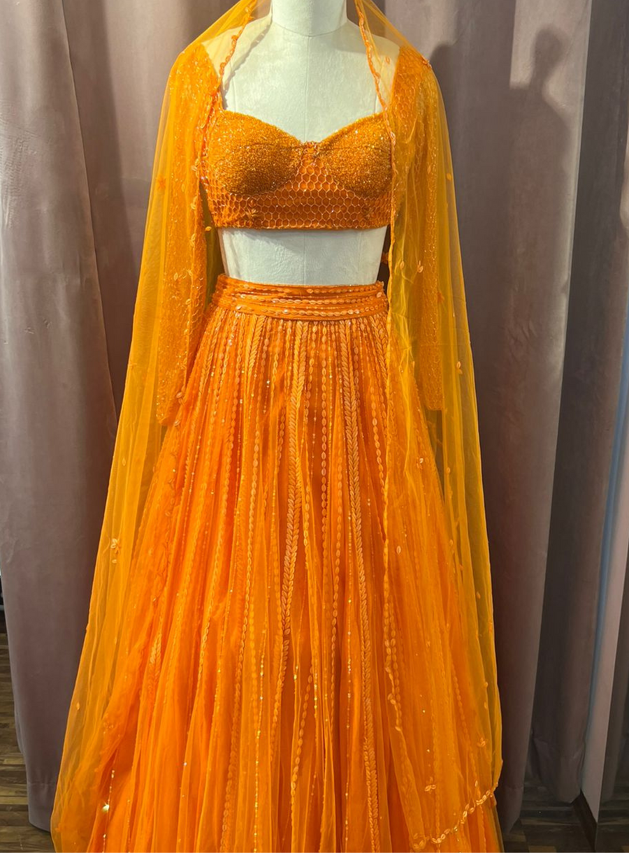 Orange candy sequin lehenga with embellished blouse and sheer dupatta, shown on a mannequin