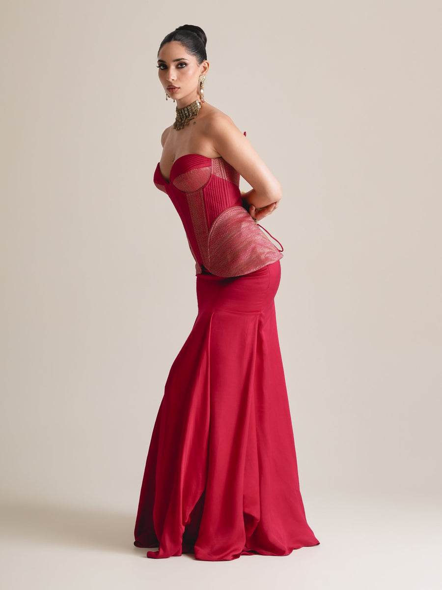 Crimson red sweetheart corset with rose-pink side panels and peplum over a flared floor-length skirt, full-length side view, arms behind