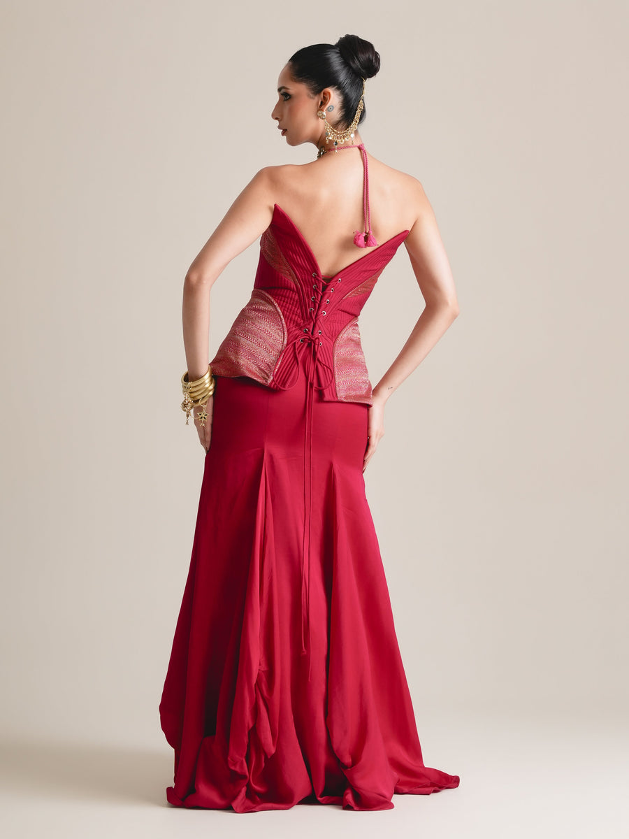 Back view of the crimson corset with lace-up back, halter tie and rose-pink panelled peplum, over a flared red skirt, full length
