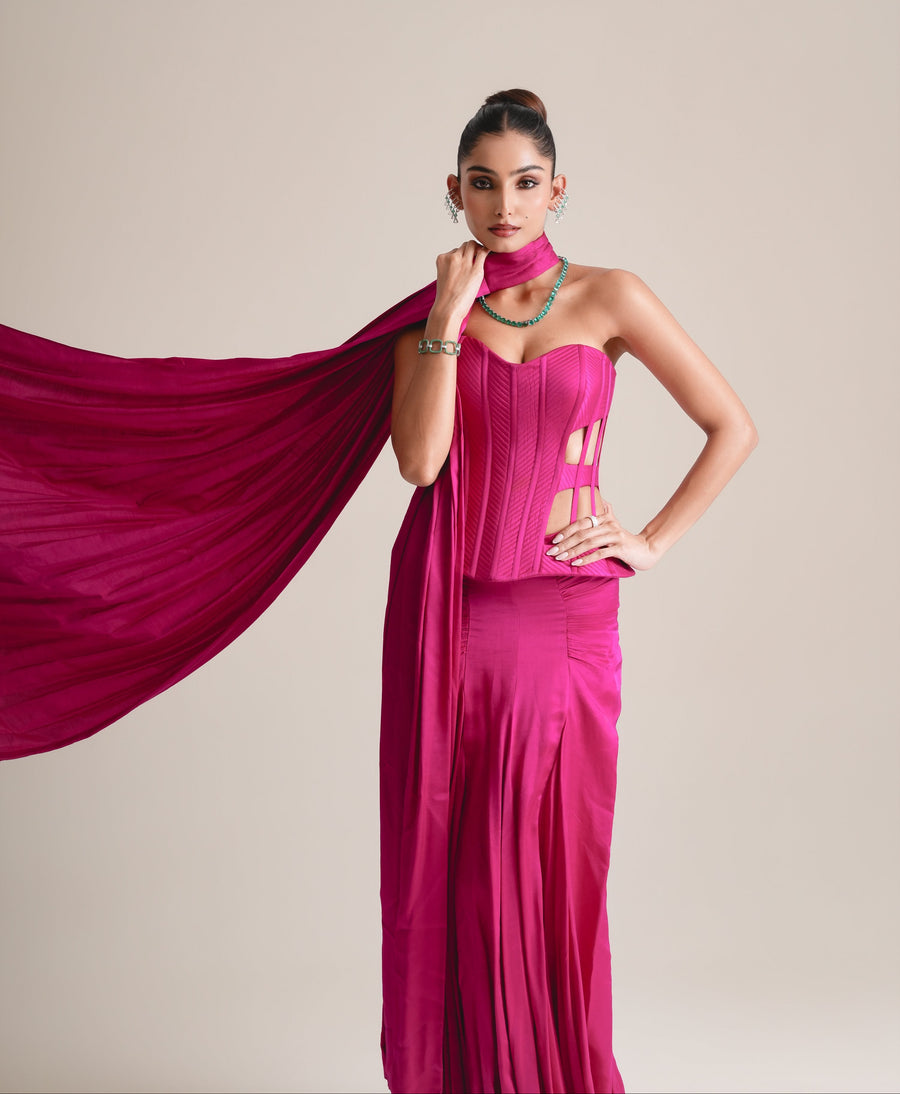 Three-quarter view of the hot-pink cage corset with the stole flying out to one side, hand on hip