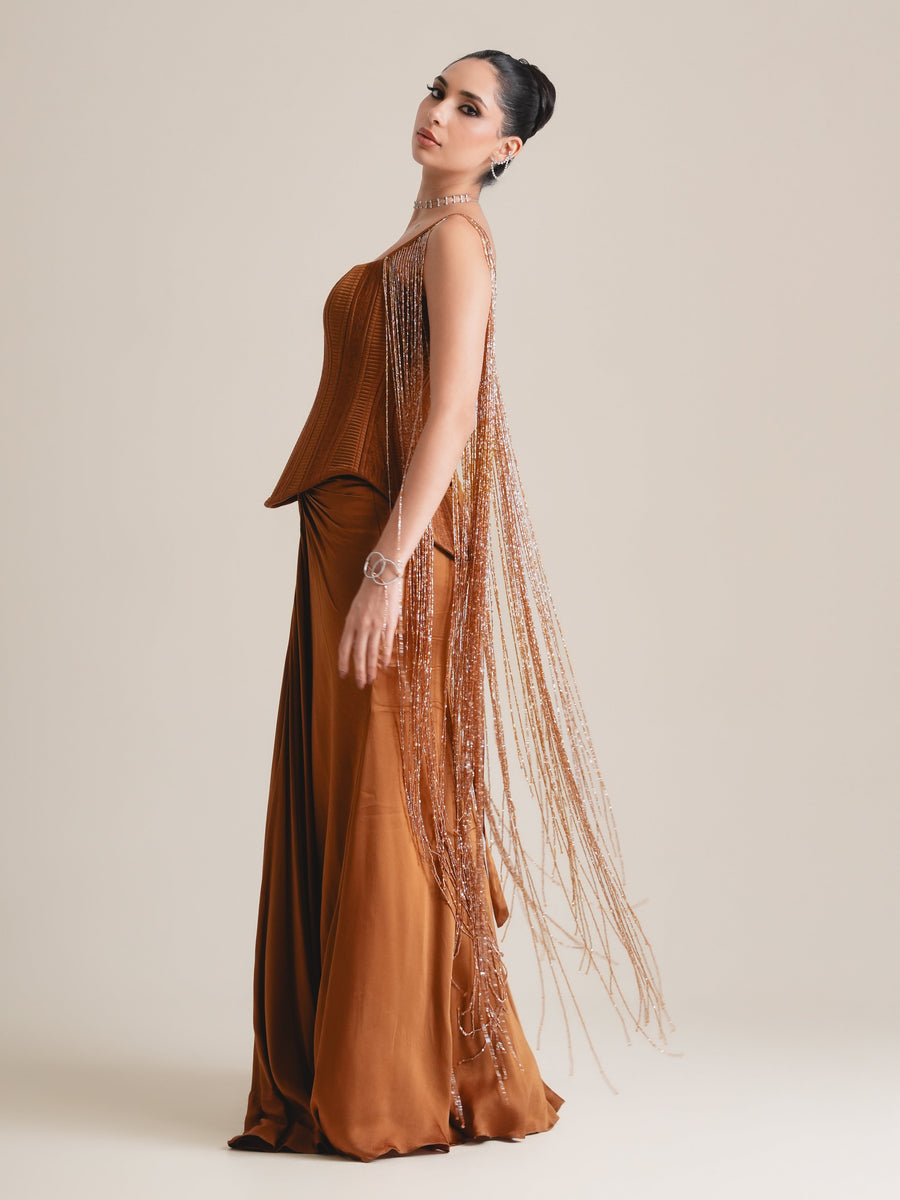 Rust-copper corset with long beaded tassel fringe and a floor-length drape skirt, full-length side view