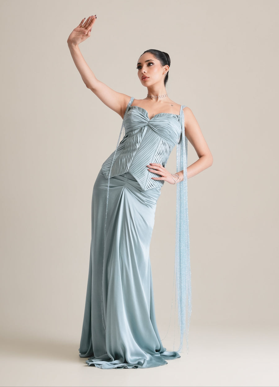 Ice-blue pleated sweetheart corset with fringed side drapes and a draped satin skirt, full-length view, one arm raised
