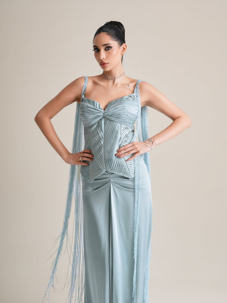 Three-quarter view of the ice-blue pleated sweetheart corset with fringed side drapes, hands on hips