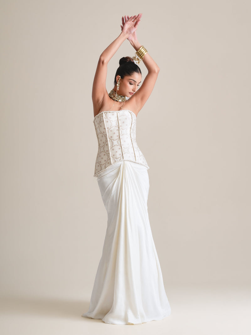 Ivory pearl-embroidered strapless corset with a draped satin fishcut skirt, full-length view with both arms raised overhead