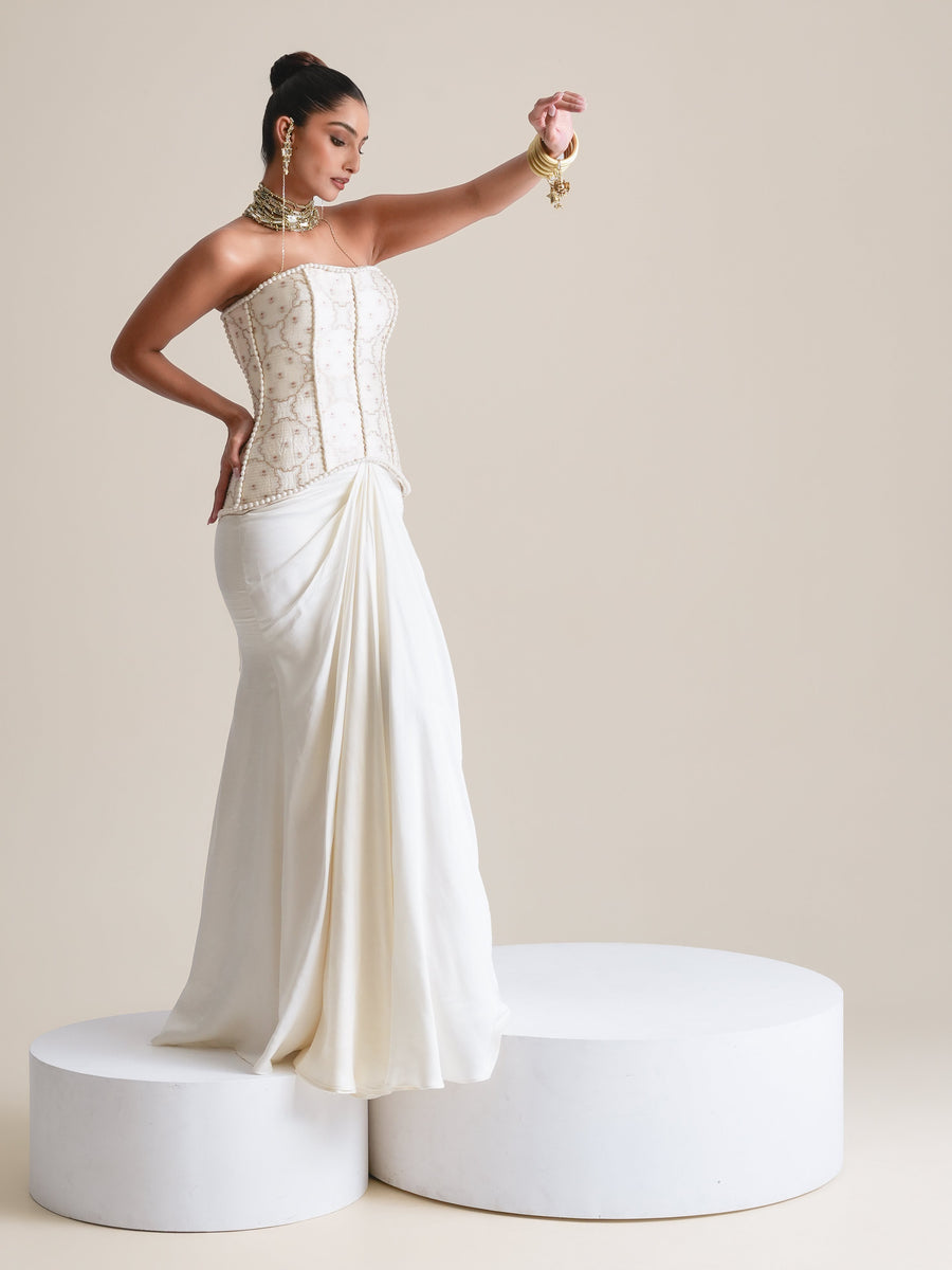 Ivory pearl-embroidered strapless corset and draped skirt, full-length view standing on white plinths, one hand raised