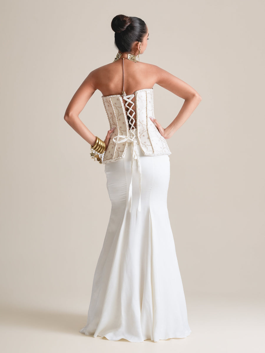 Back view of the ivory strapless corset with lace-up back and a satin fishcut skirt, full length, hands on hips