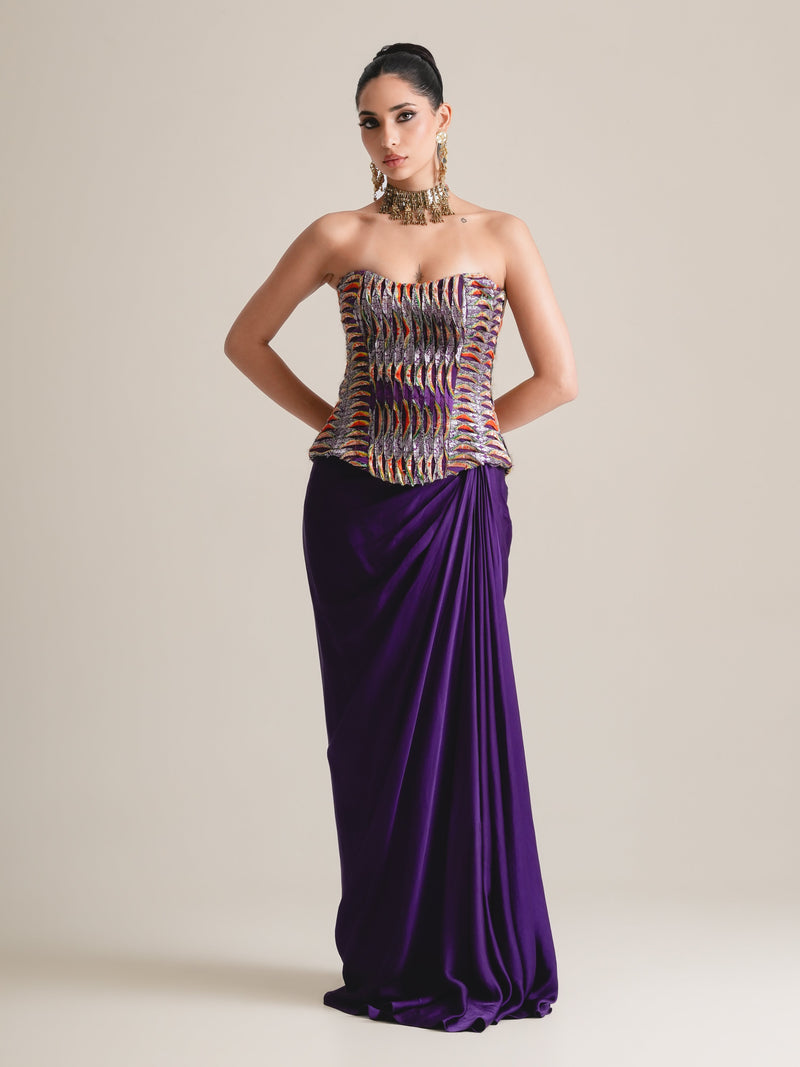 Multicolour woven-pattern strapless corset with a draped purple skirt, full-length front view, hands on hips
