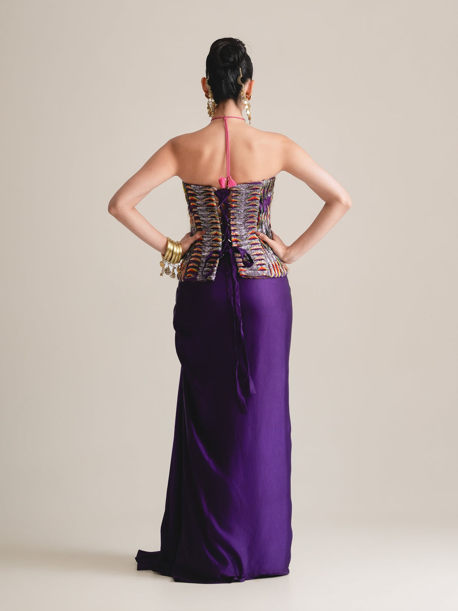 Back view of the multicolour strapless corset with lace-up back and a long purple drape skirt, full length, hands on hips