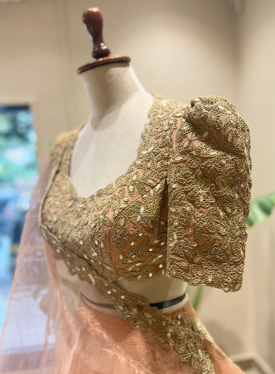 Close-up of the peach lehenga's marodi embroidered puff sleeve blouse