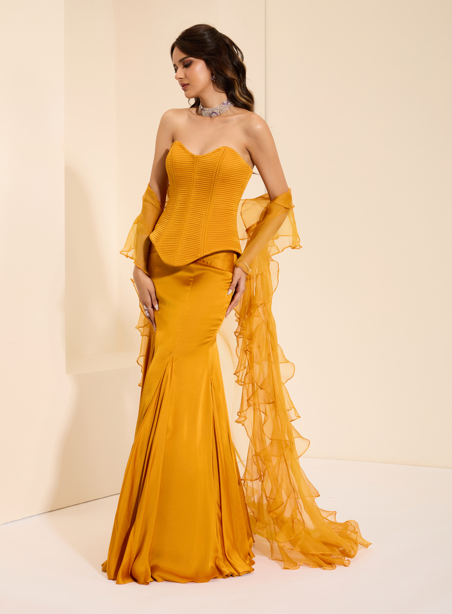 Full-length view of the mustard quilted corset with fishtail skirt and ruffled organza cape