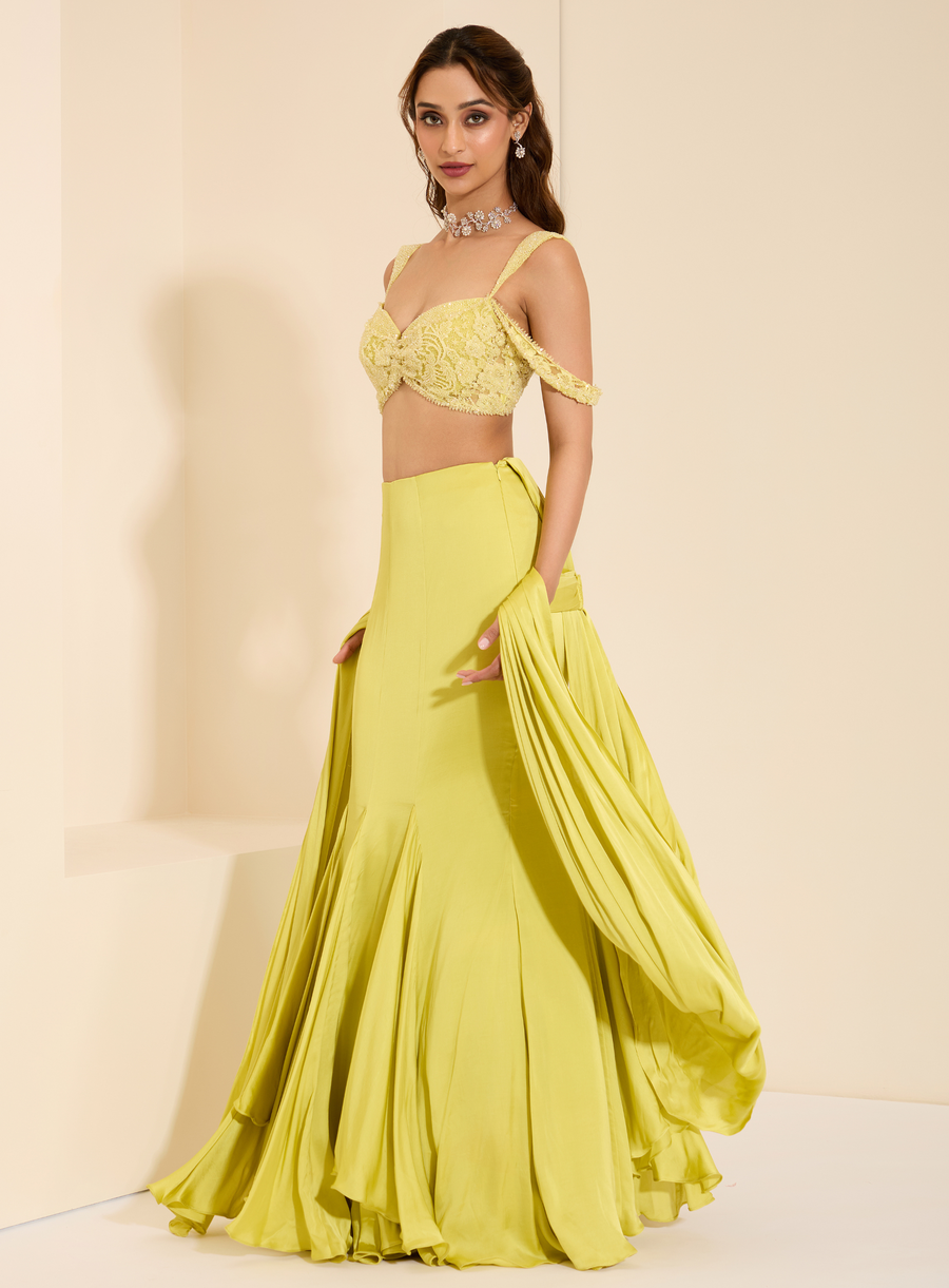 Full-length side view of the lime yellow lace bustier with fishtail drape saree