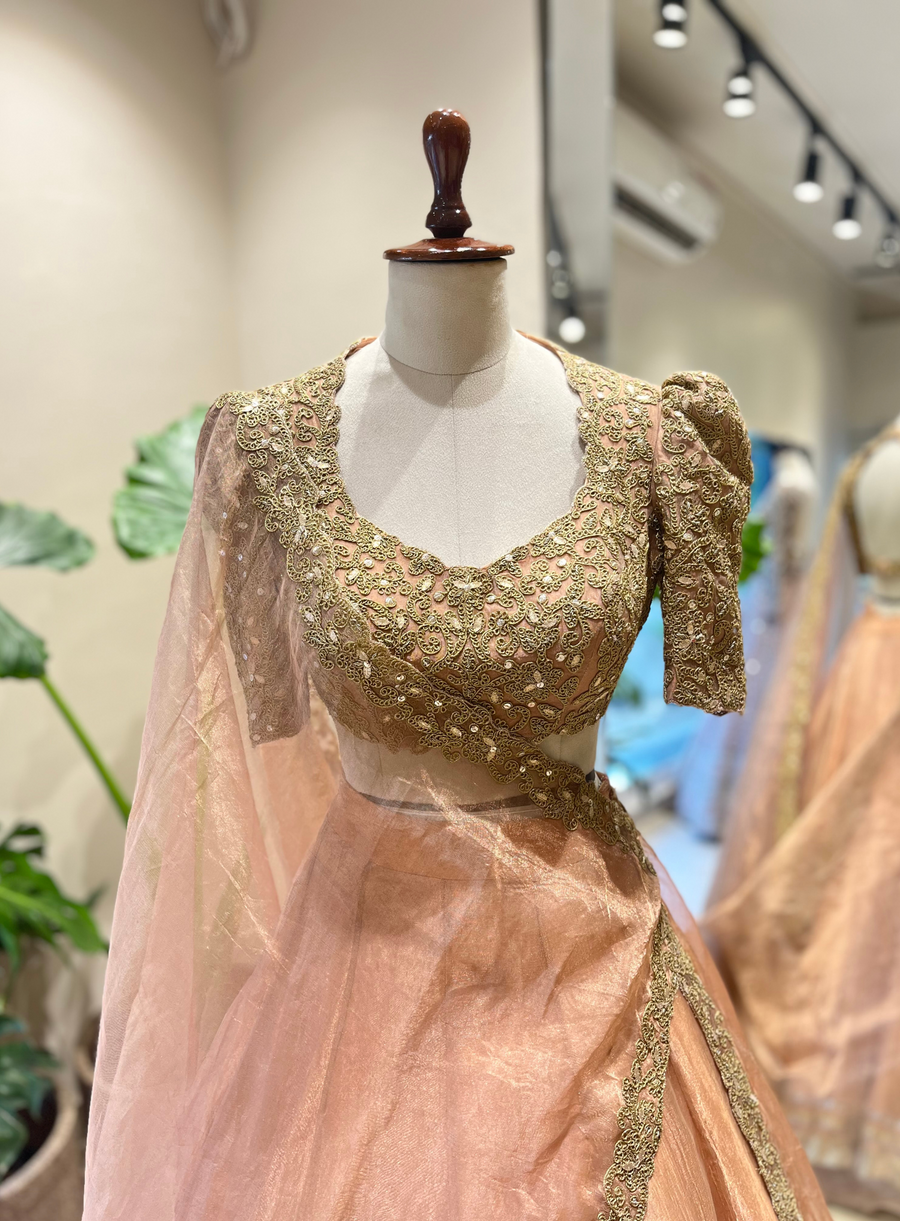 Peach marodi embroidered lehenga blouse with puff sleeves and sheer dupatta on a mannequin