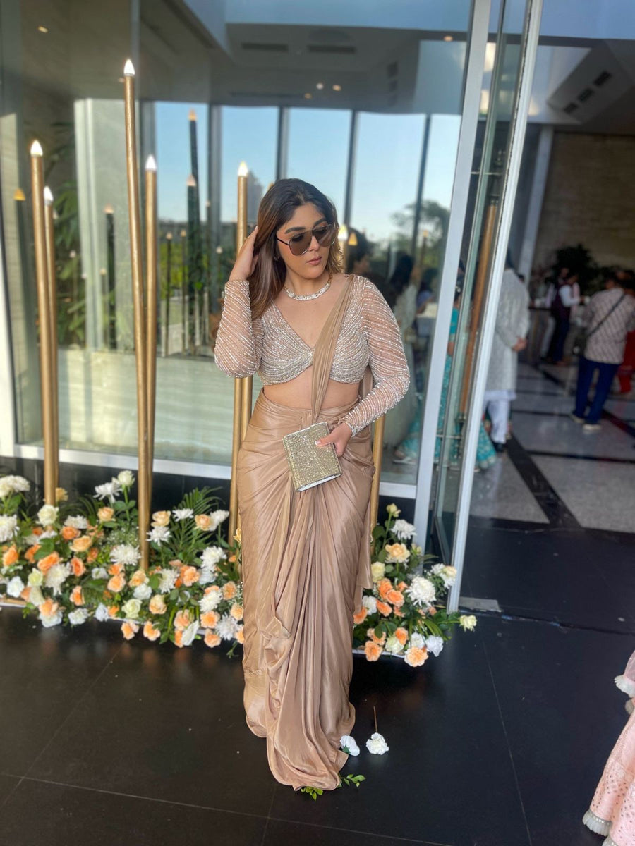 Full-length view of the silver embellished full sleeve blouse with nude drape saree at an event
