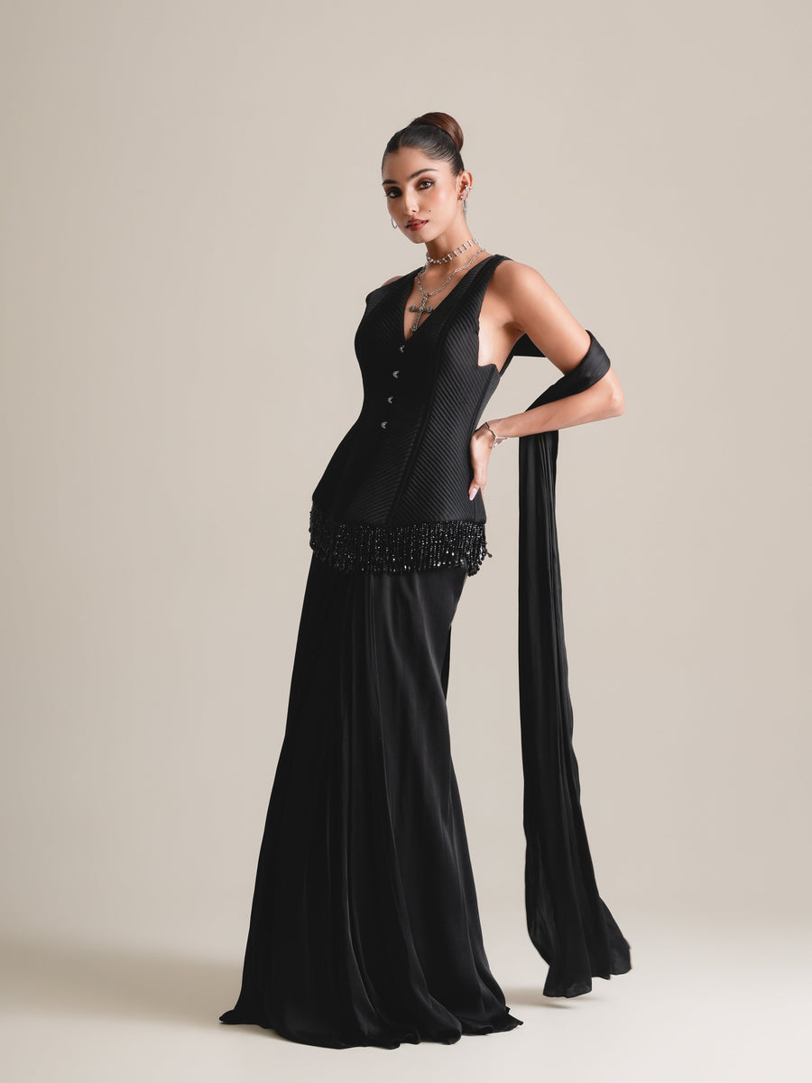 Black V-neck quilted corset with beaded fringe and long drape skirt, stole over the arm, full-length three-quarter view