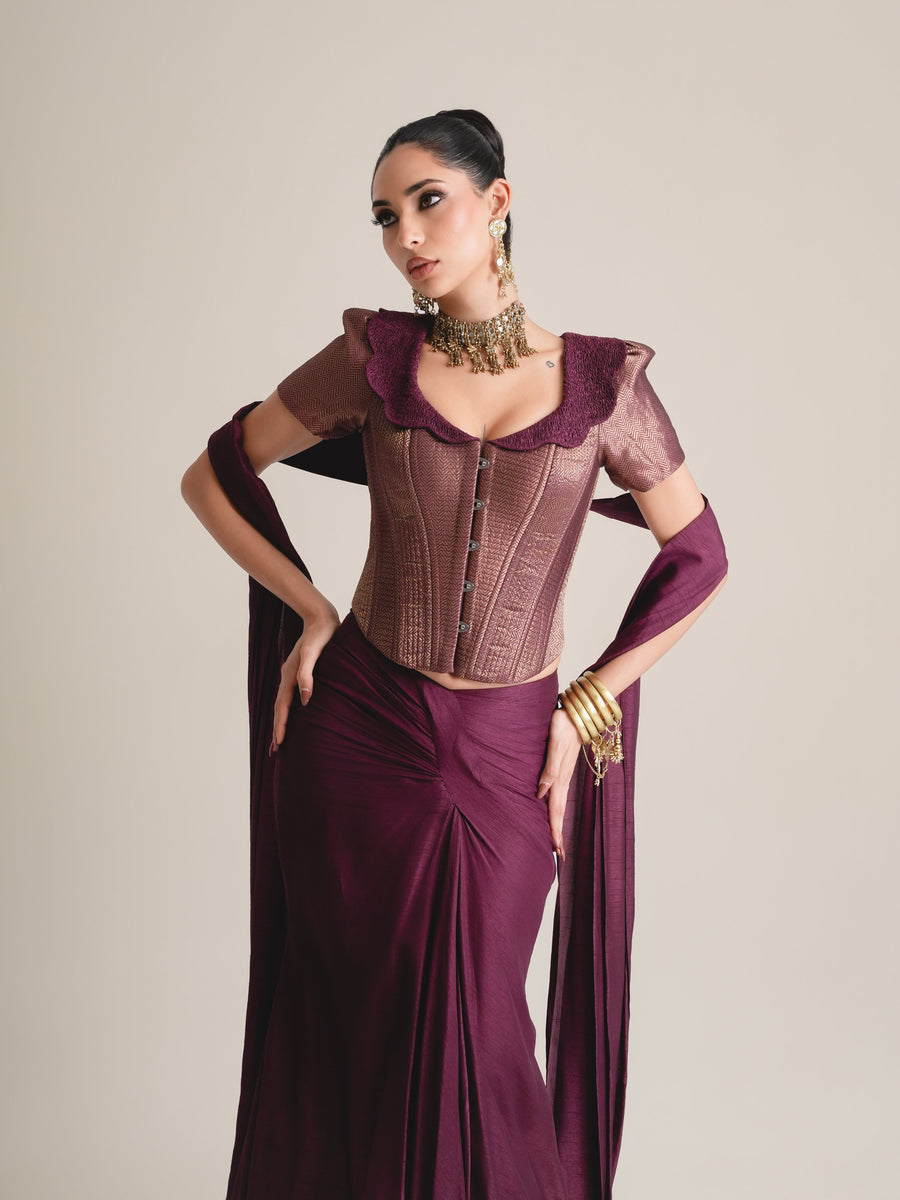 Three-quarter view of the plum puff-sleeve corset with scalloped collar and buttoned front, hands on hips, stole draped