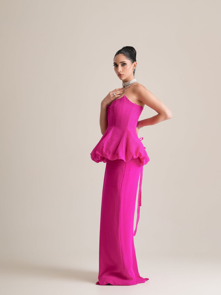 Fuchsia pink strapless bubble-peplum corset with a straight pencil skirt, full-length three-quarter view