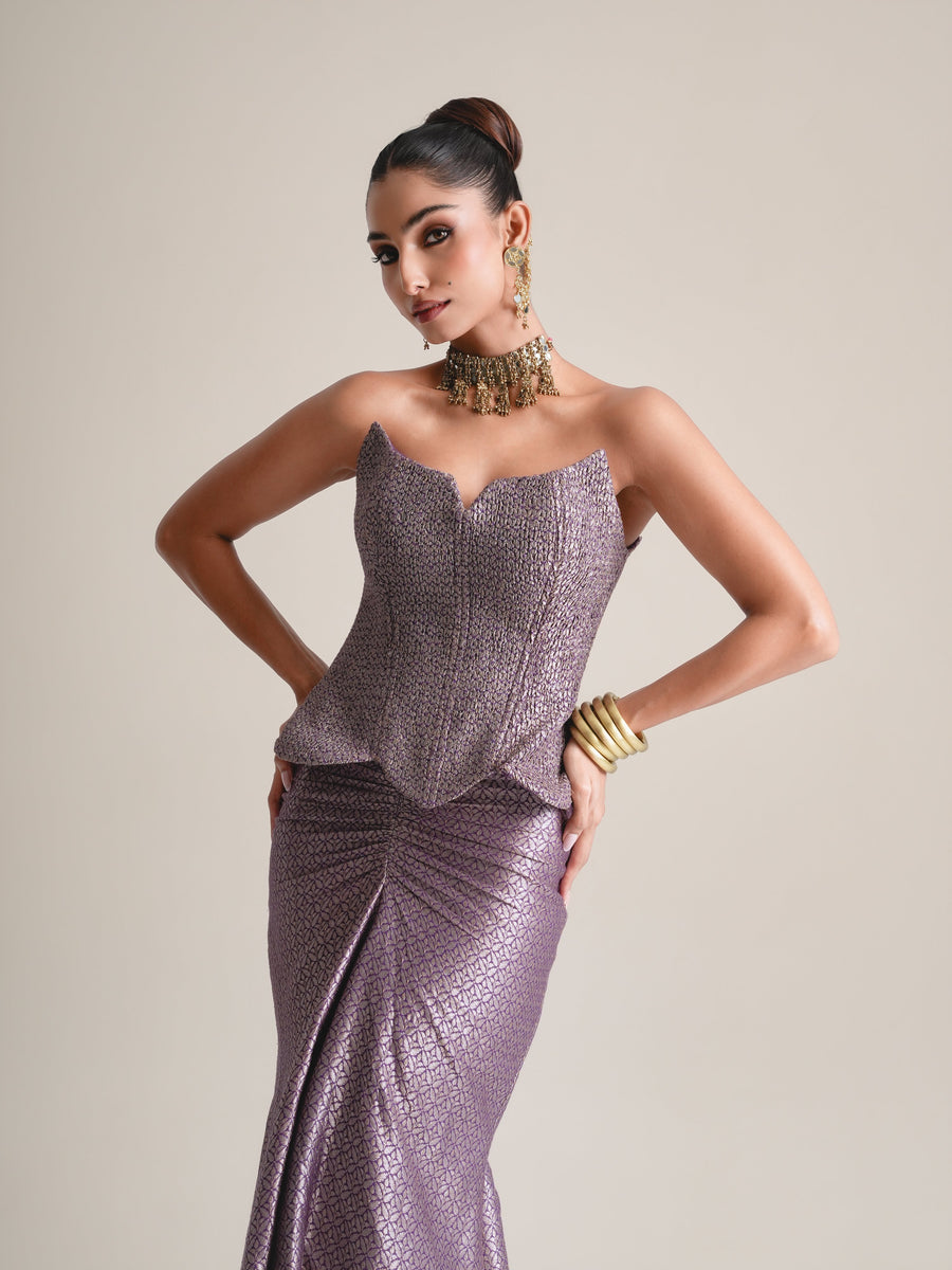Three-quarter view of the lilac-grey scalloped-neck brocade corset with hands on hips and the ruched skirt front