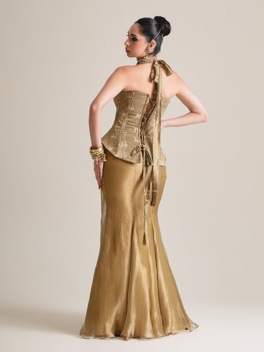 Back view of the antique-gold halter corset tied at the neck, with the sheer tissue skirt, full length