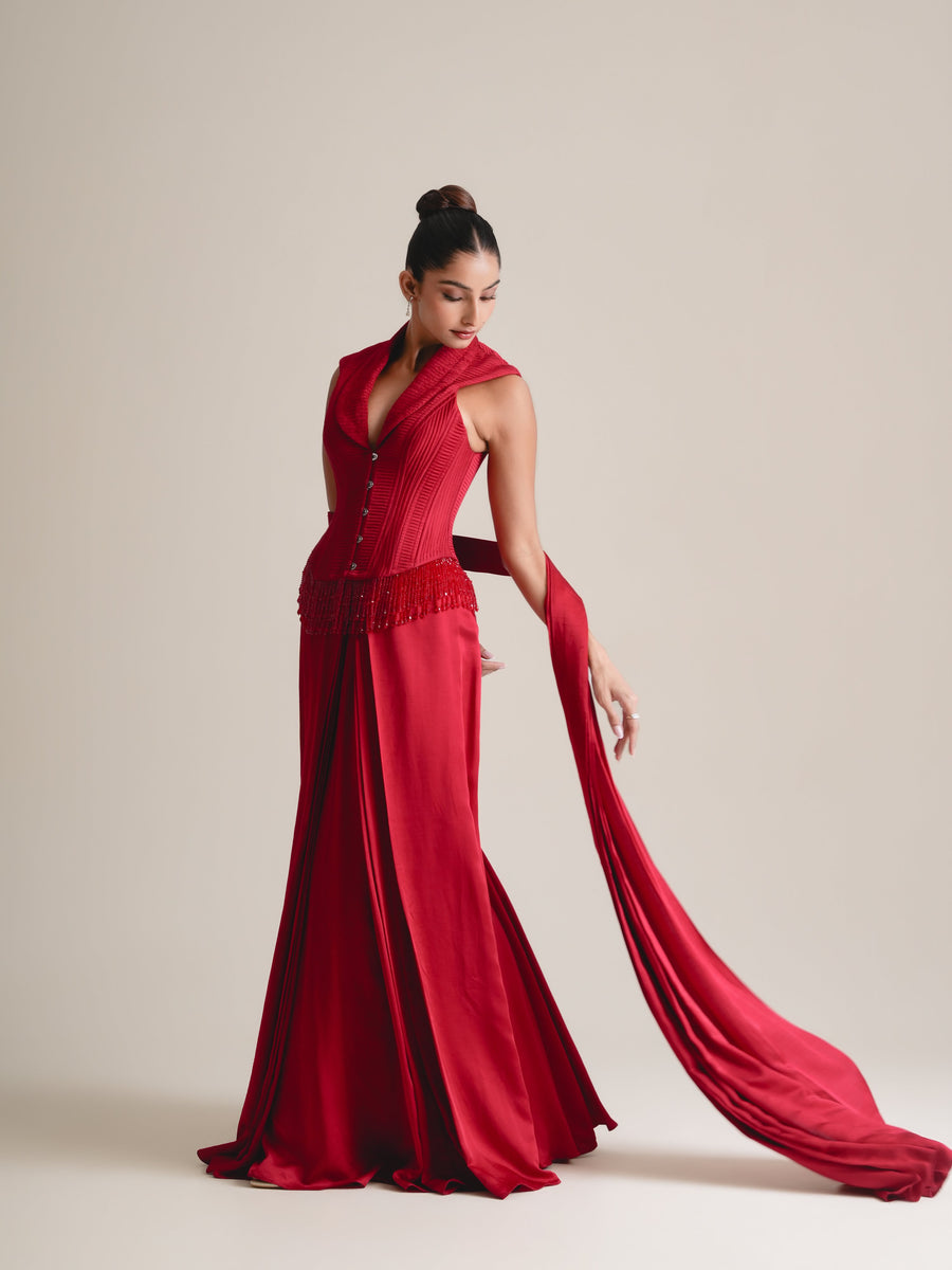 Red shawl-collar quilted corset with beaded fringe, drape skirt and a long stole trailing behind, full-length view